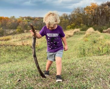 baby hiking with a stick