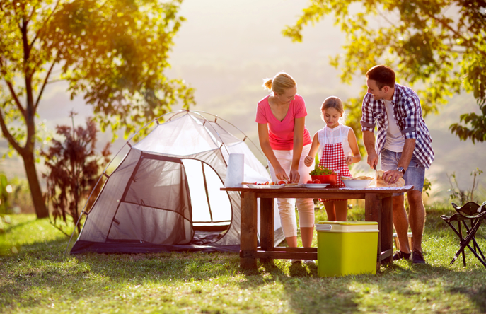 family of three camping in the summer