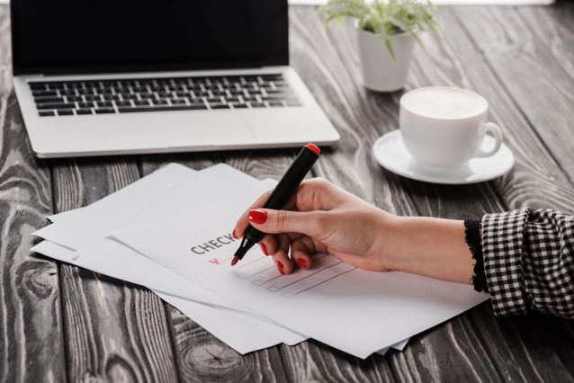 woman with pen making a camping checklist