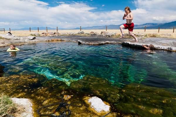 Kid jumping into the MEADOW HOT SPRINGS