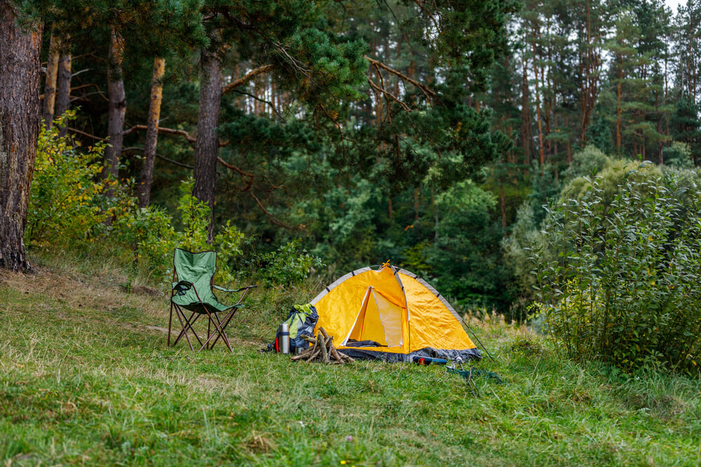 camping with tent and campfire and kayaks