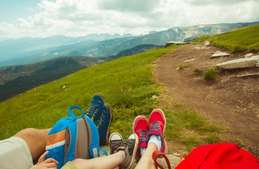 three people showing off their hiking shoes