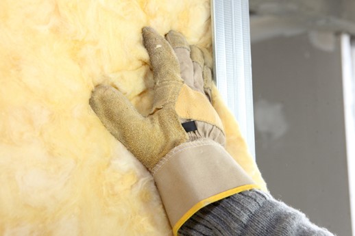 guy in glove fixing rv insulation