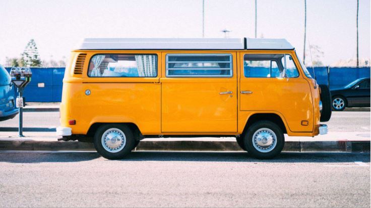Old orange VW van with a white roof