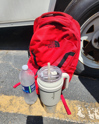 red backpack with water bottle and mug